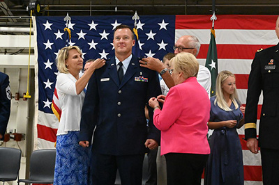 Brig. Gen. Robert A. Schulte has the rank of brigadier general pinned onto his uniform by his family members 
