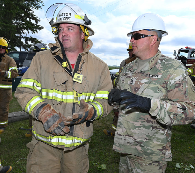 Sgt. 1st Class Benji Boll of the 188th Engineer Company, discusses search and rescue plans with Jason Sletten, the Hatton, N.D. assistant fire chief, during Exercise Vigilant Guard at Golden Lake, N.D., Aug. 5, 2020. (Air National Guard photo by Chief Master Sgt. David H. Lipp)