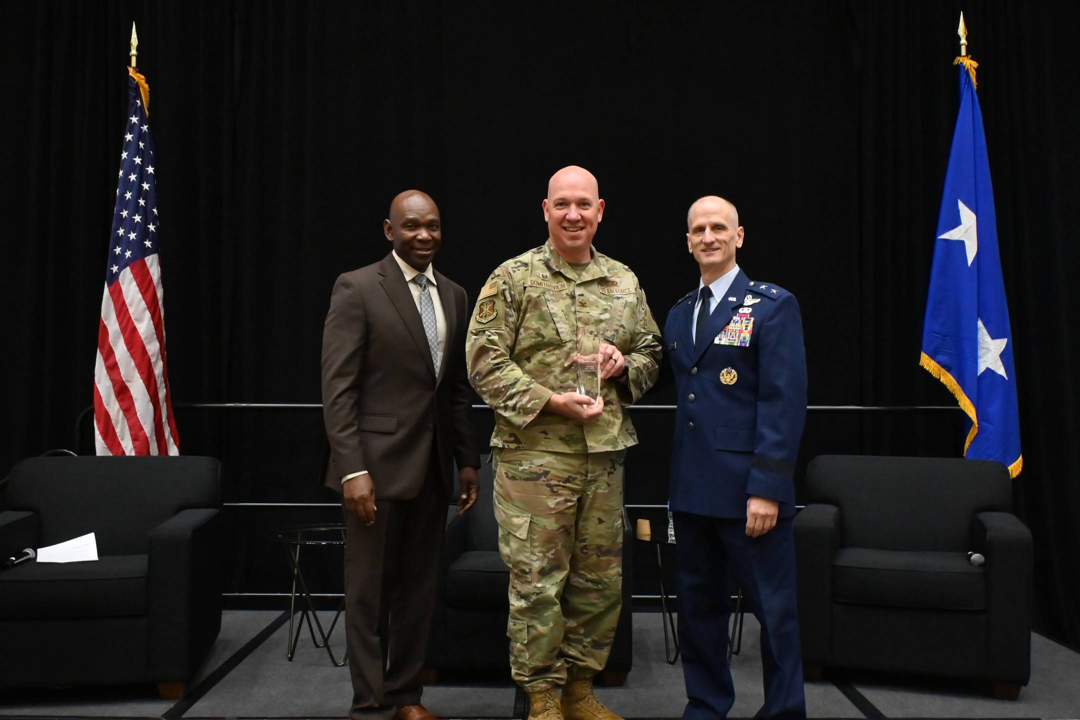 U.S. Air Force Col. Christopher Domitrovich, commander, 119th Wing, North Dakota Air National Guard, receives the Spaatz Trophy from (left) retired Maj. Gen. Ondra Berry, NGAUS vice chair-Air, and (right) U.S. Air Force Maj. Gen. Randy Efferson, the acting director of the Air National Guard, at the 148th NGAUS General Conference & Exhibition, Indianapolis, Indiana, August 31, 2026. 