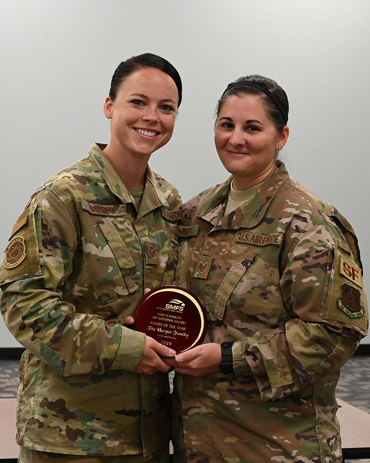 Airmen of the 219th Security Forces Squadron Staff Sgt. Jessica Harper, left, and her wife Staff Sgt. Sarah Harper, hold their North Dakota Air National Guard Family of the Year award, which was presented to them at Minot Air Force Base, N.D., on July 18, 2020. (U.S. Air National Guard photo by Chief Master Sgt. David H. Lipp)