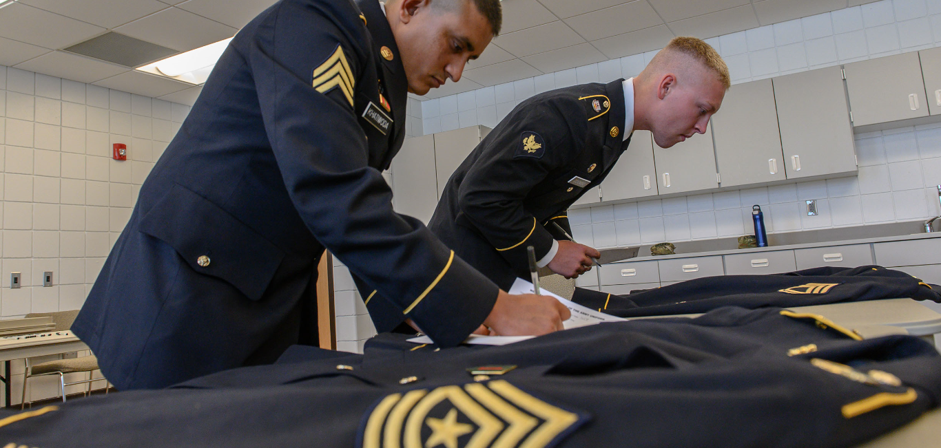 Staff Sgt. Tek Khatiwoda, left, 1st Battalion, 188th Air Defense Artillery Regiment, and Spc. John Coombs, 188th Engineer Company, participate in the uniform inspection test during the Best Warrior Competition on August 13. The competitors must correct identify deficiencies on the Army Service Uniform (ASU). (U.S. Army National Guard photo by Spc. Drew Ward, 116th Public Affairs Detachment)