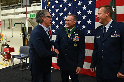 Governor Doug Burgum, left, shakes hands with Brig. Gen. Robert J. Becklund