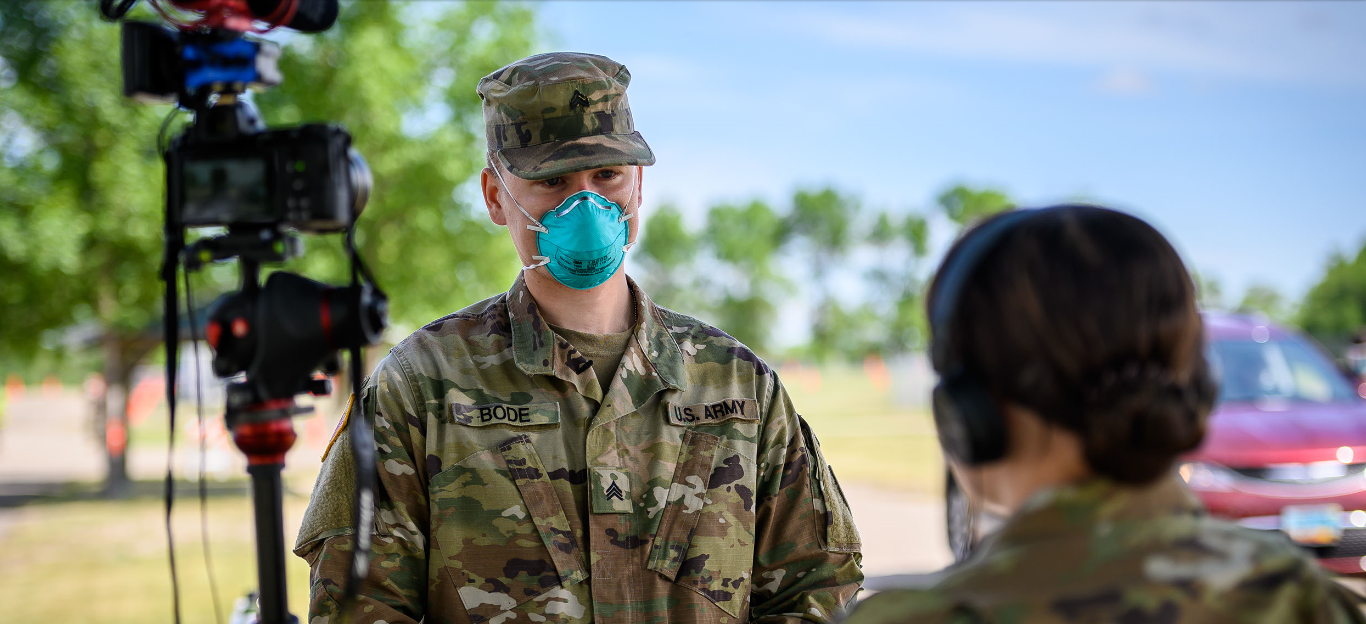 Sgt. Chase Bode, 816th Military Police Company, is interviewed by Sgt. Michaela Granger, 116th Public Affairs Detachment, at the COVID-19 mobile testing site in Jamestown, N.D. on June 18, 2020. (U.S. Army National Guard photo by Sgt. 1st Class Brett Miller, 116th Public Affairs Detachment)