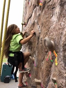 Child climing rock wall