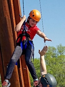 Child coming off of a rock wall